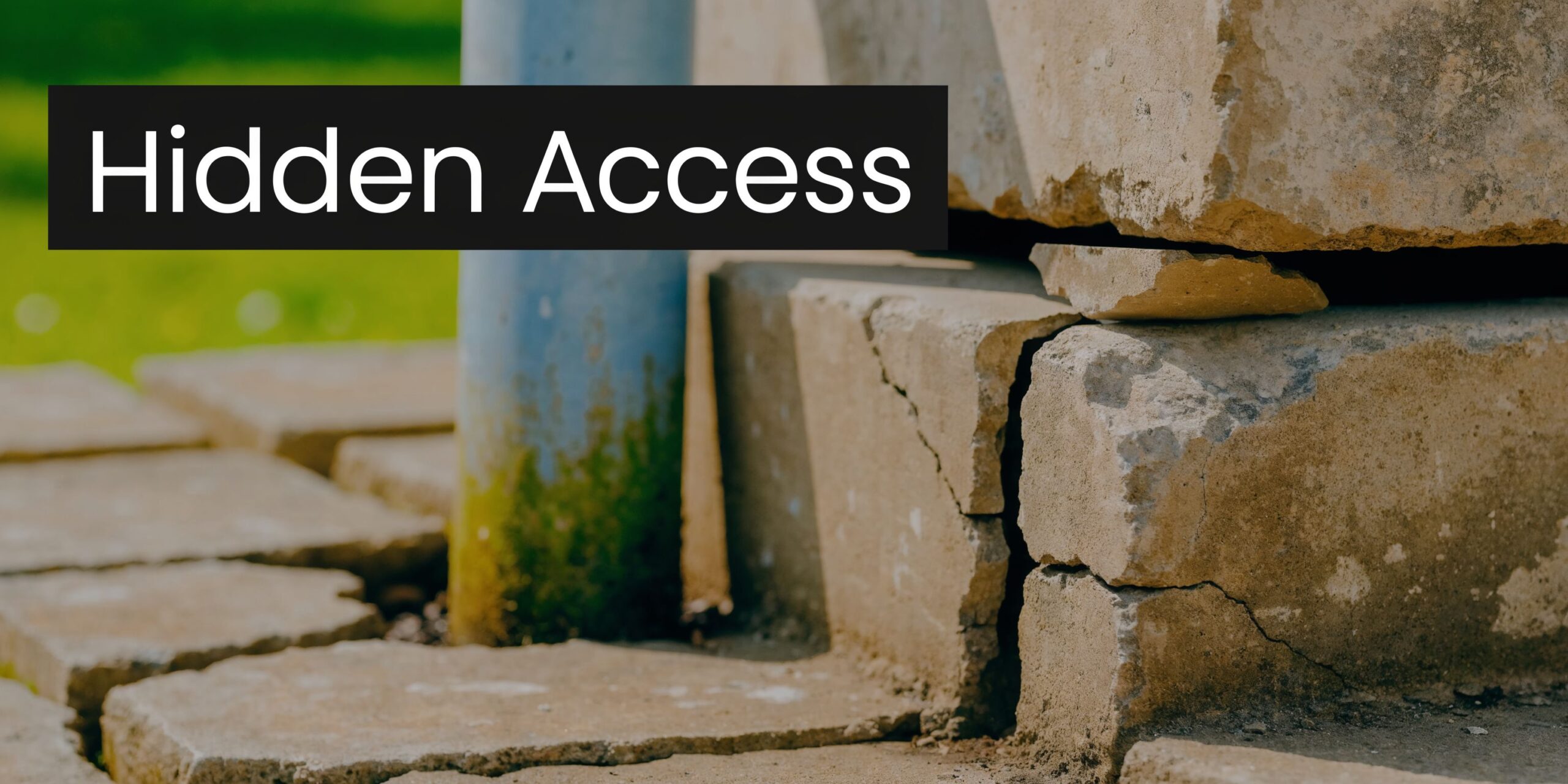 A crack in the exterior brick foundation of a house near a blue downspout pipe.