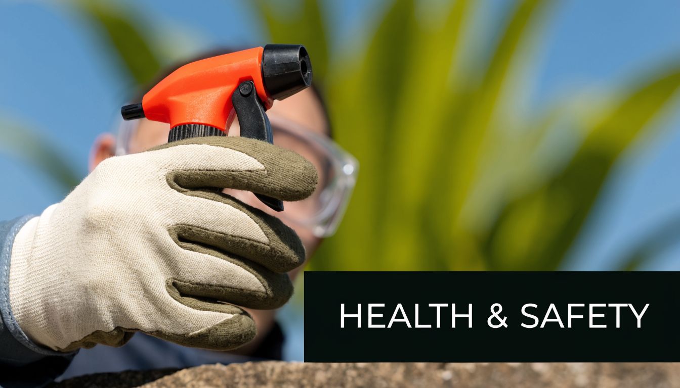 A person wearing protective gloves and safety goggles holds a professional red spray nozzle for pest control.